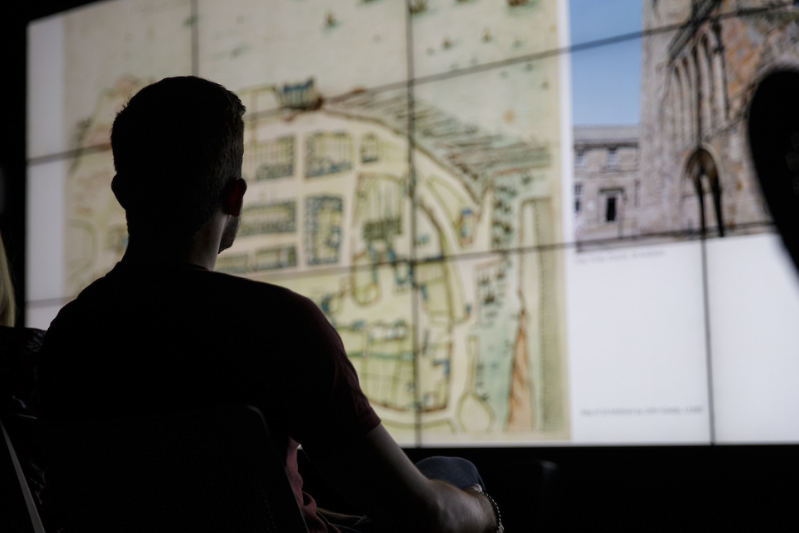 Student looks up at the projection of a map on screen